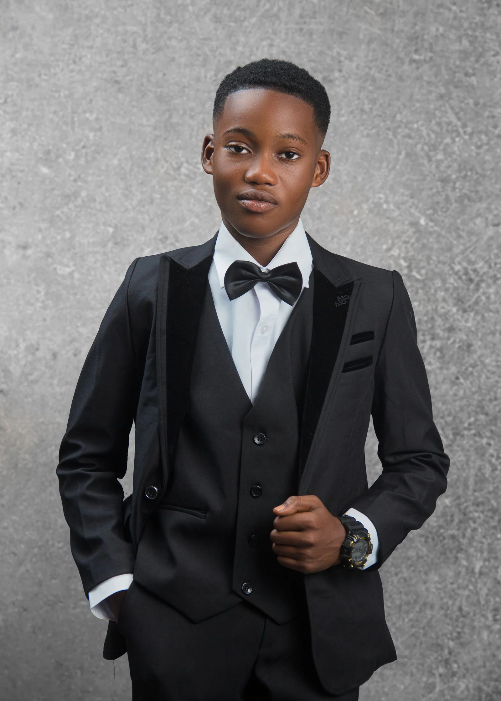 Elegant young boy in formal black suit portrait