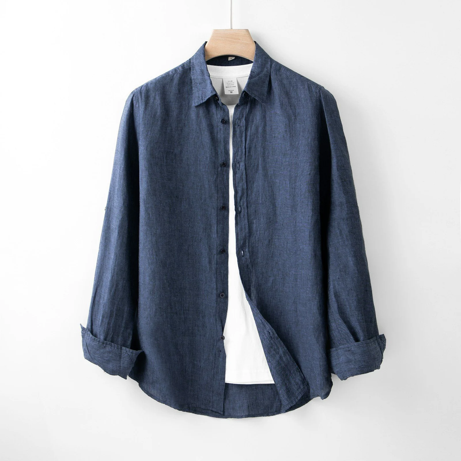A blue shirt hanging on a white wall