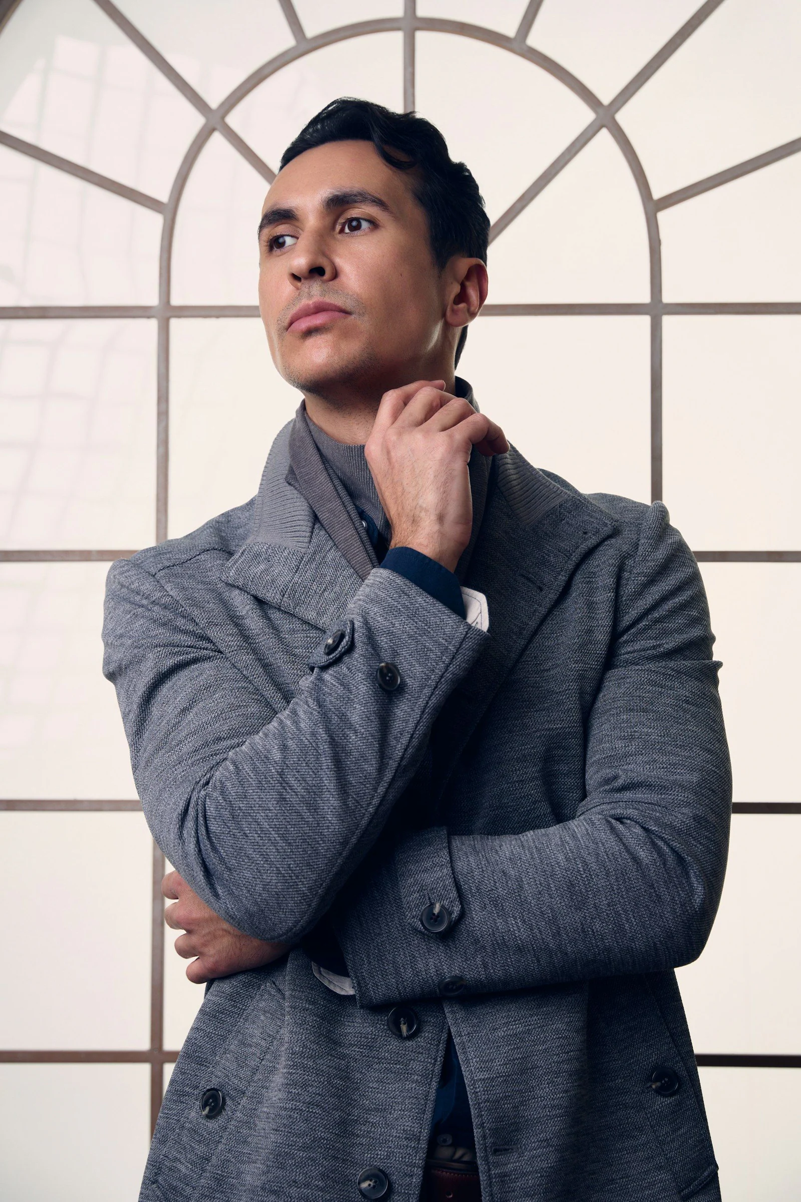 Man in grey coat by window