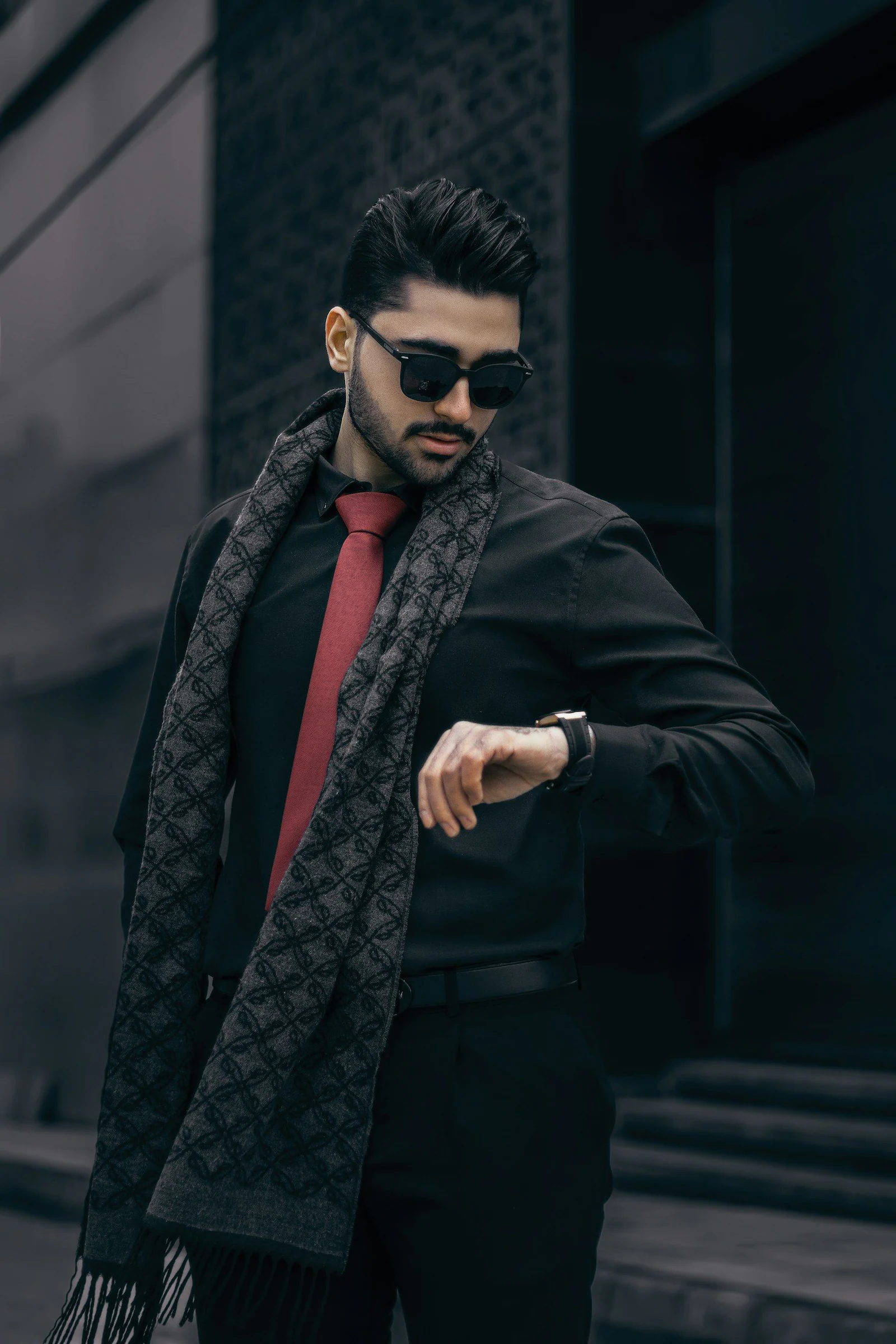 A man in a black shirt and red tie