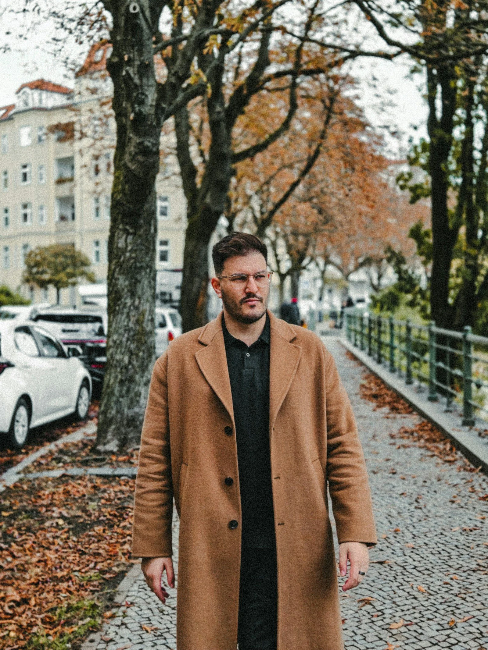A man in a coat is walking down the street