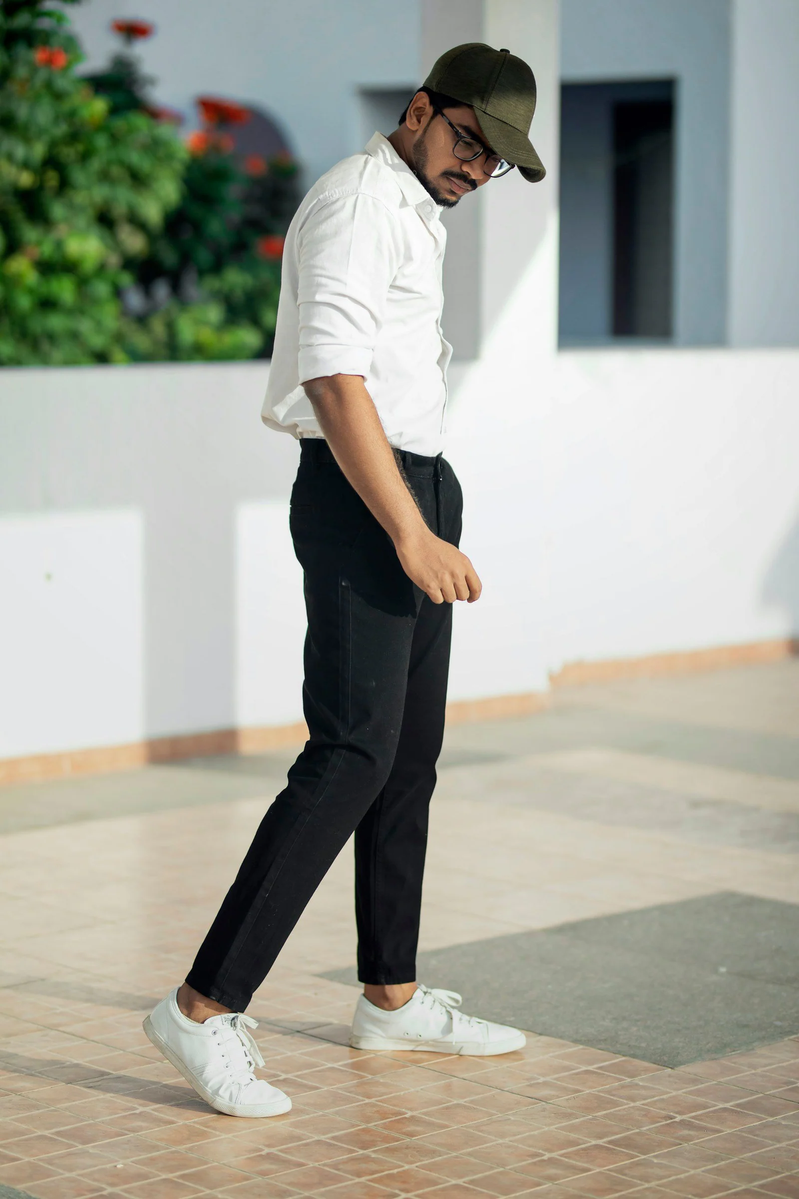 Man in white t shirt and black pants standing on white floor