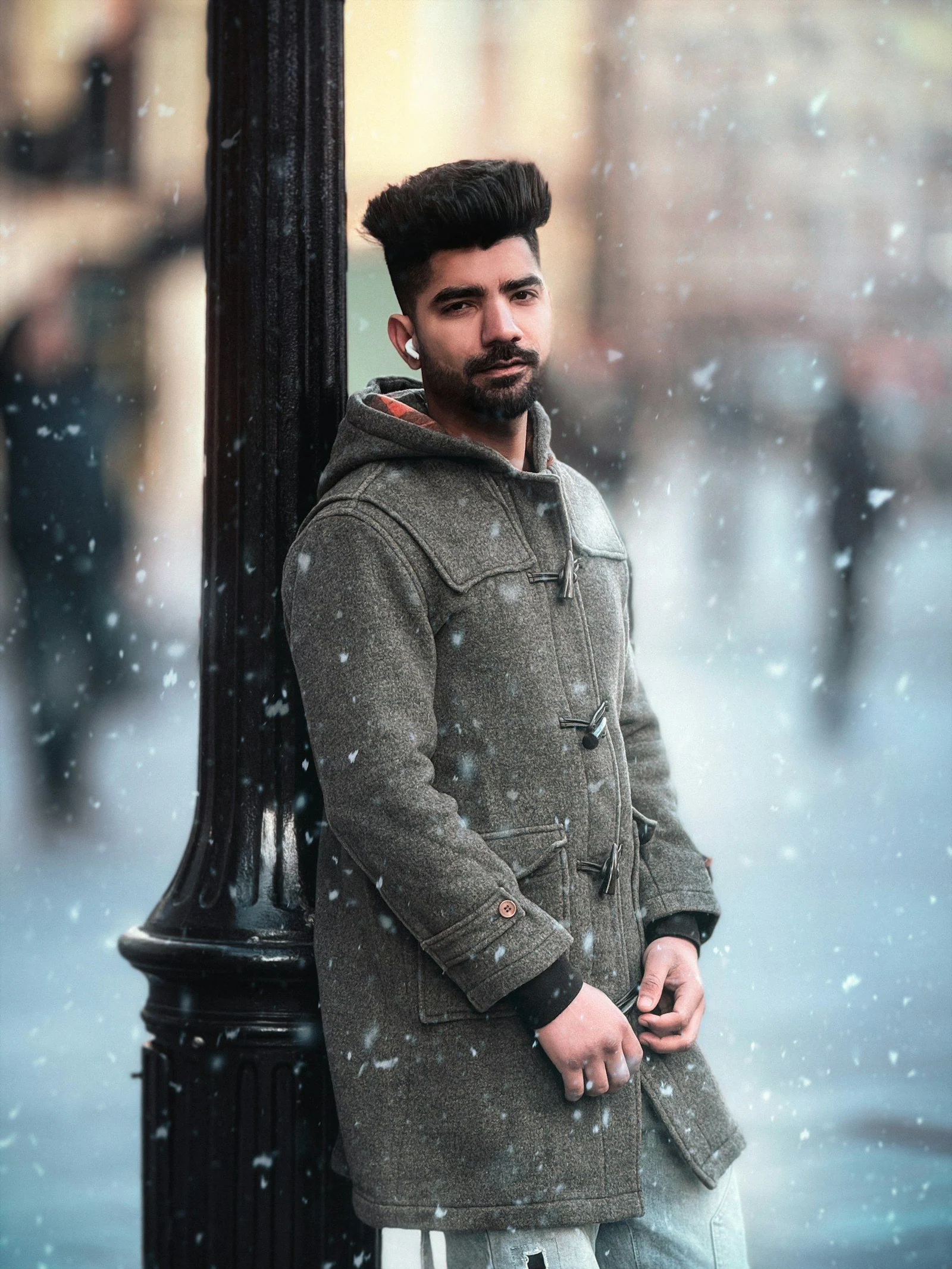Man leaning against lamppost in falling snow