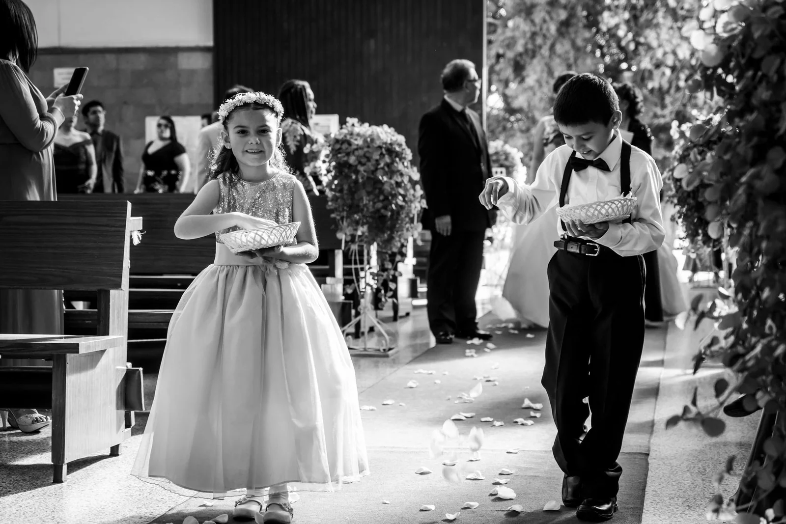 Grayscale photo of kids walking down the aisle