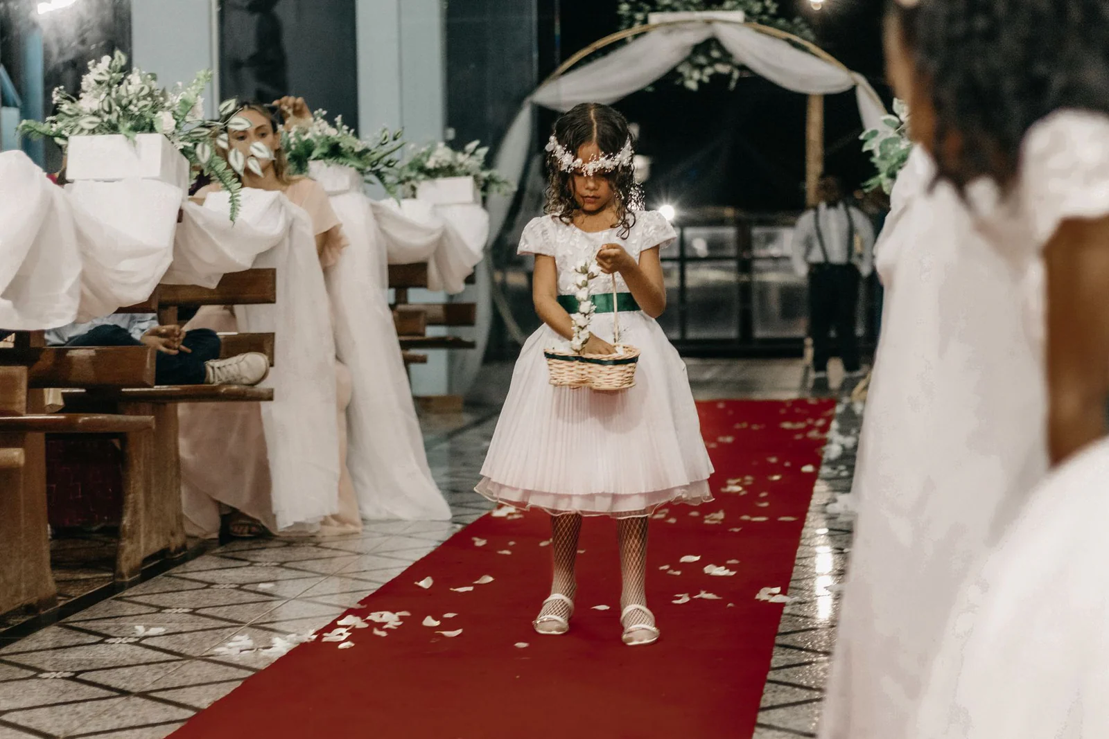 Little girl throwing flower petals on floor at wedding
