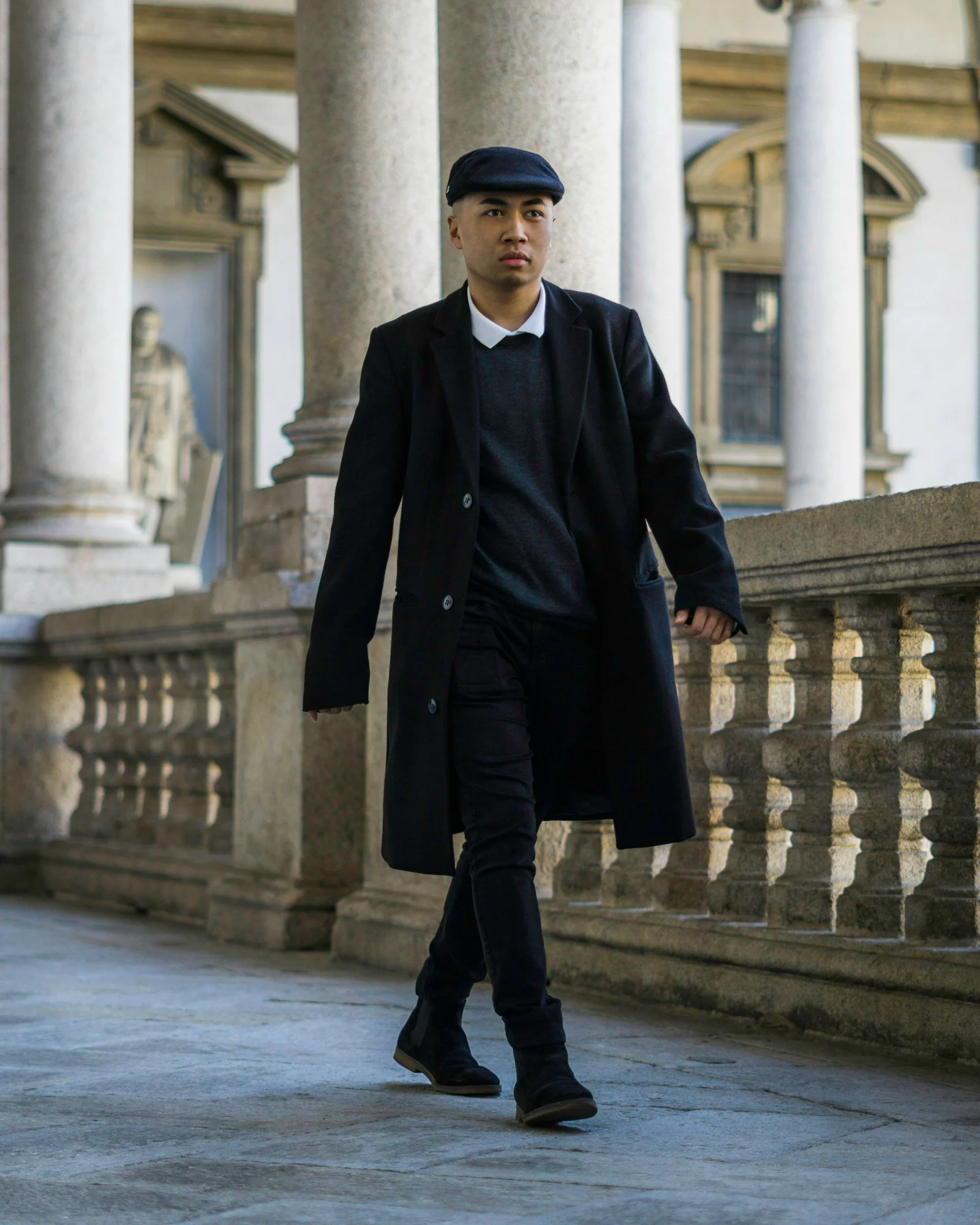 Man in black coat walking on sidewalk during daytime