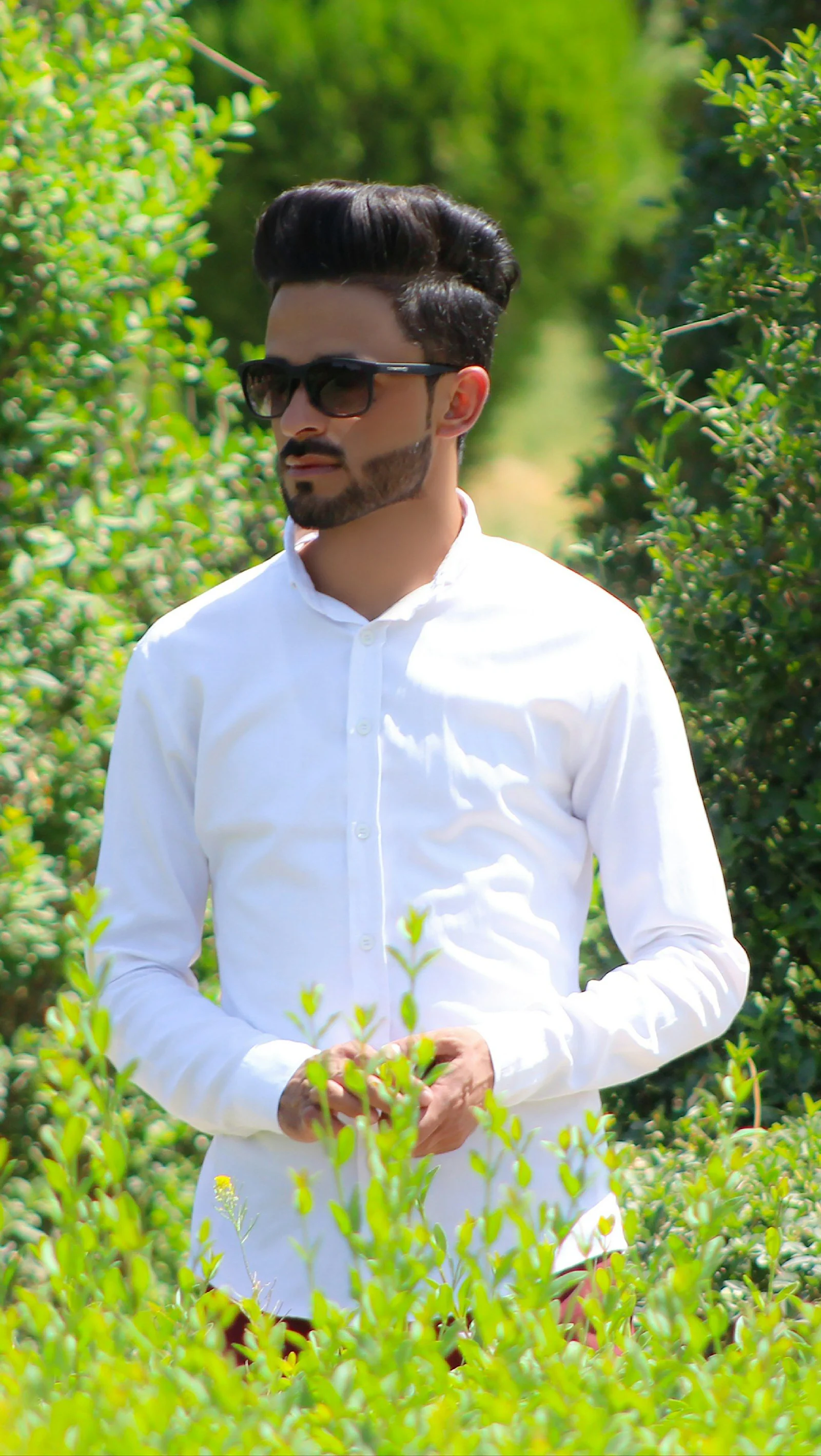 A man wearing sunglasses and a white shirt