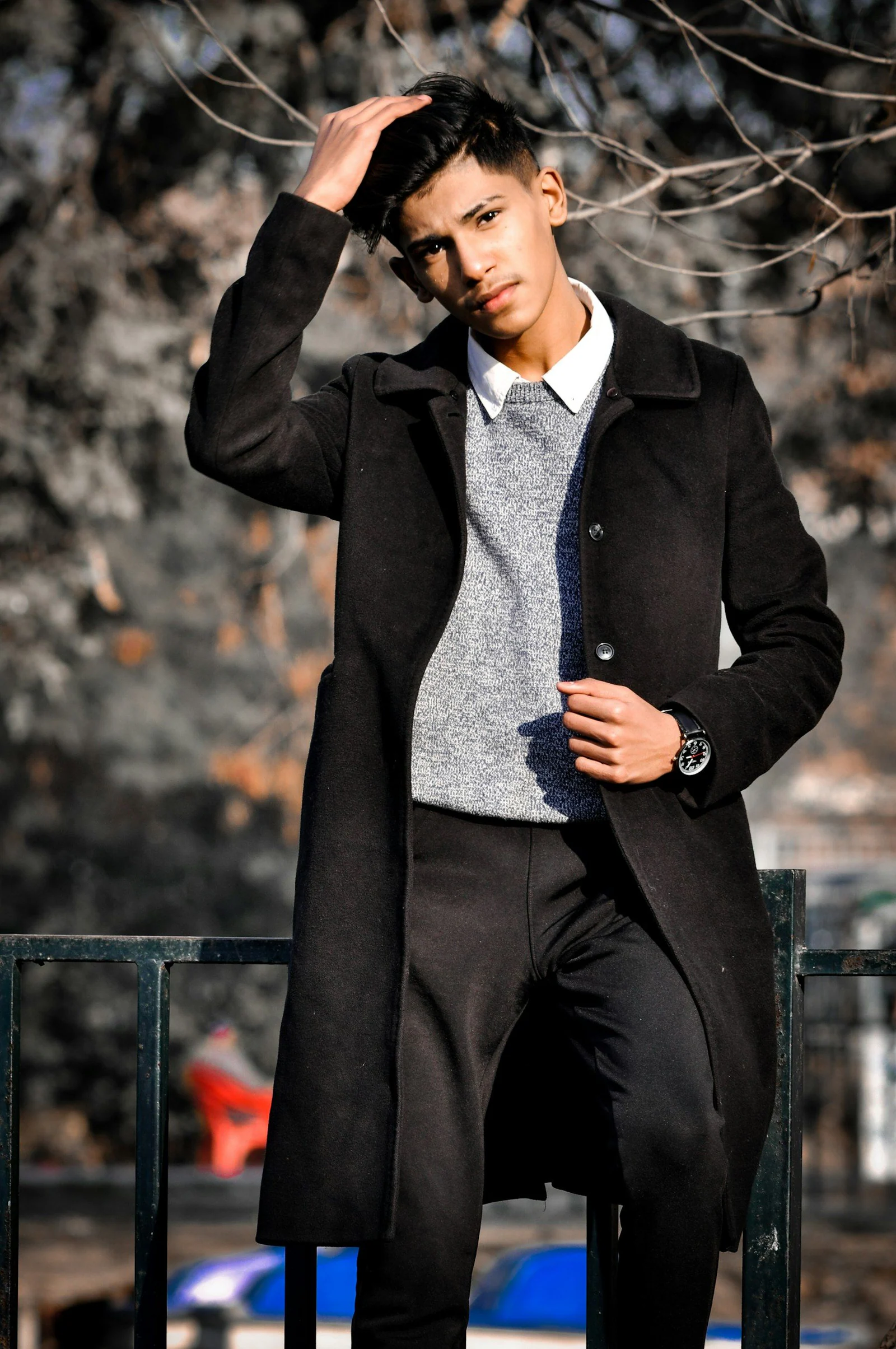 Man in black blazer and black pants standing and smiling