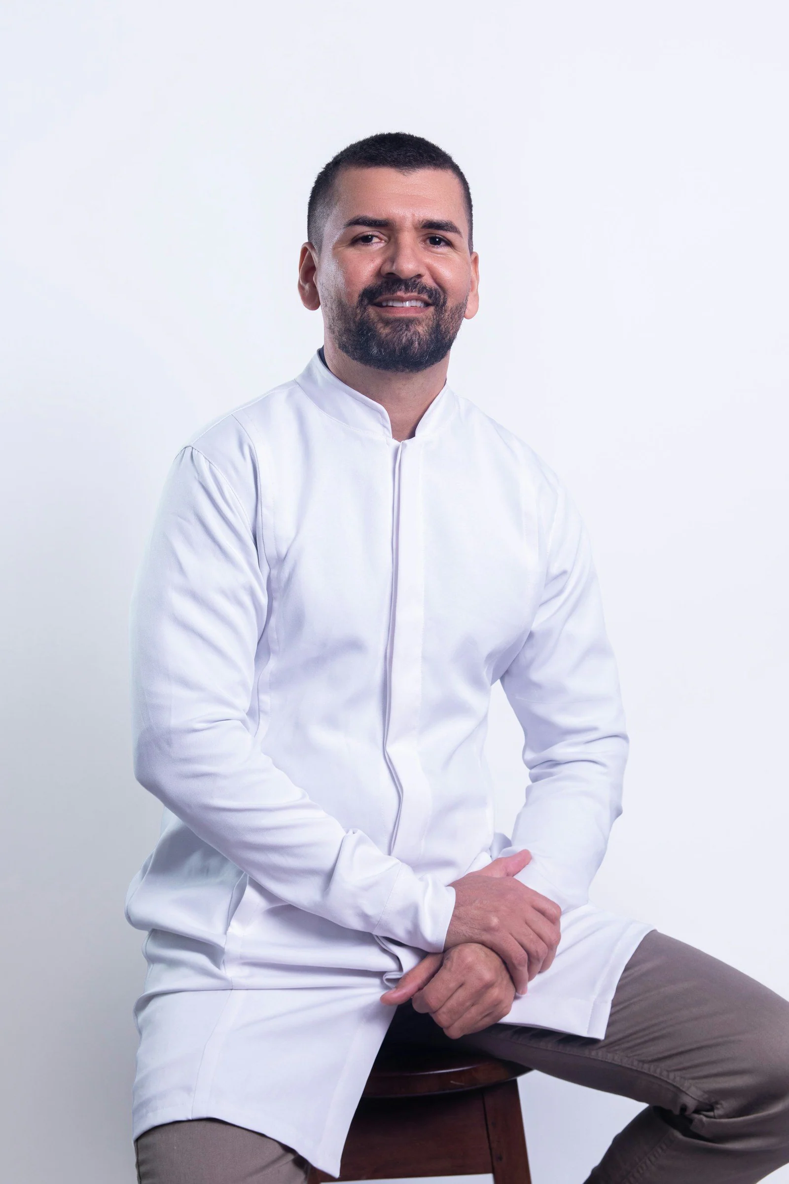 Man in white shirt smiles confidently