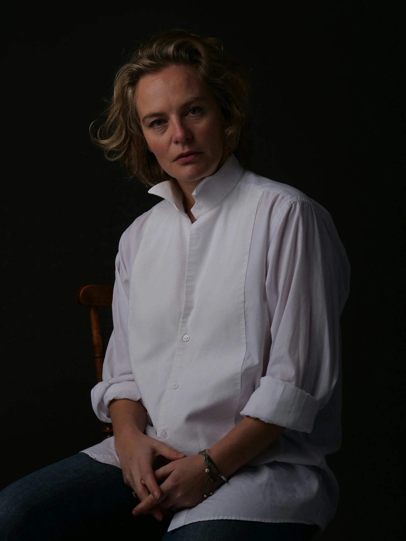 Woman in a white shirt stares pensively