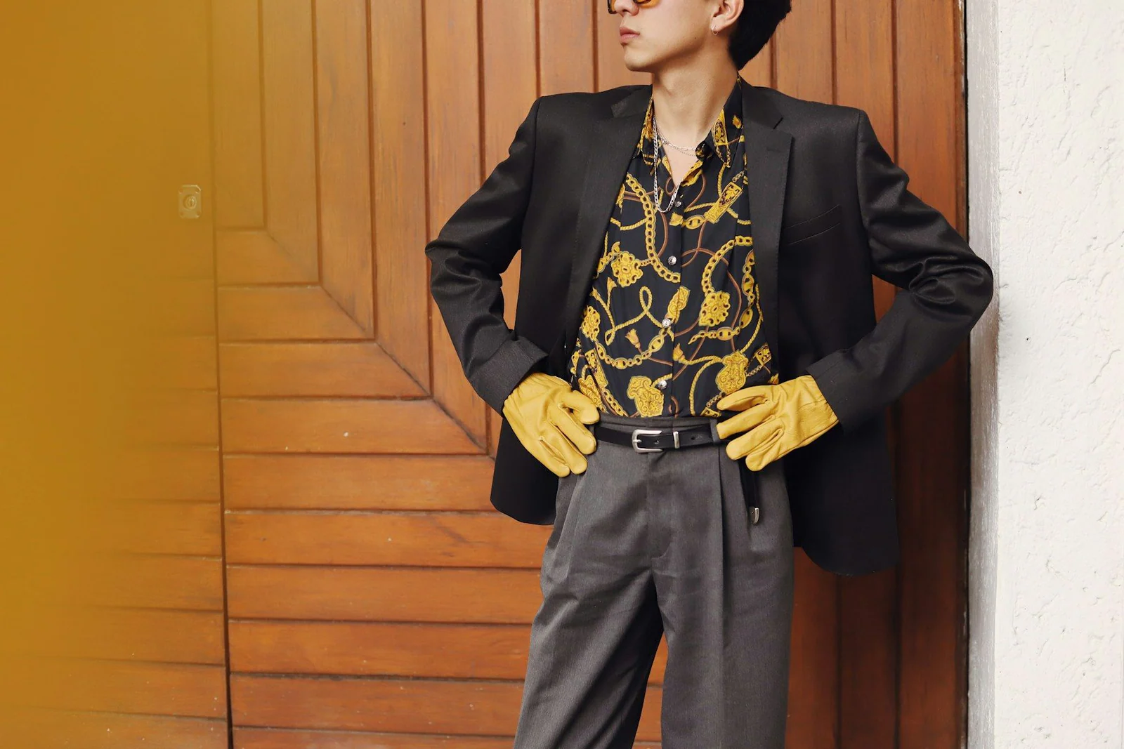 Man in stylish suit and gloves poses confidently