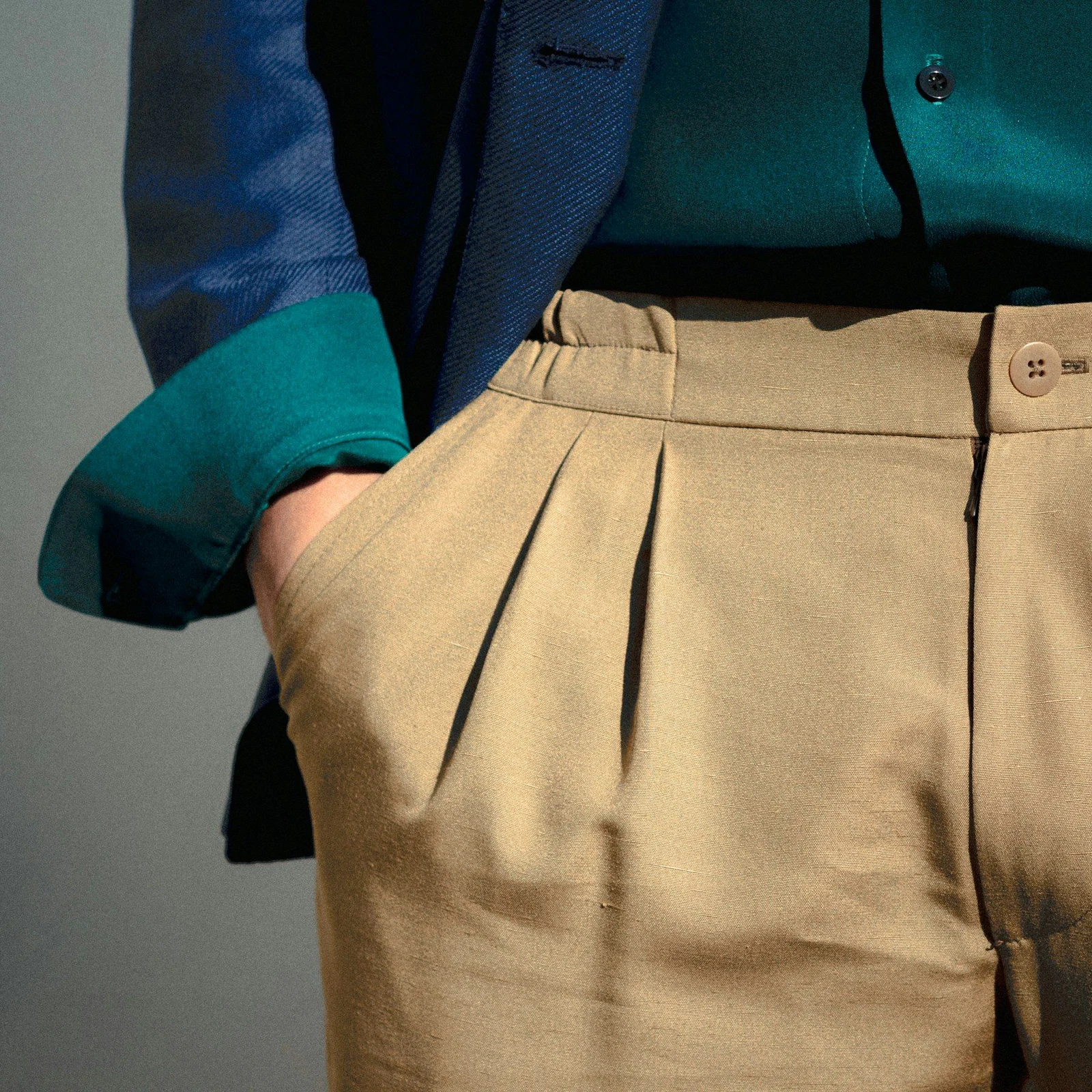 Person in blue long sleeve shirt and beige skirt