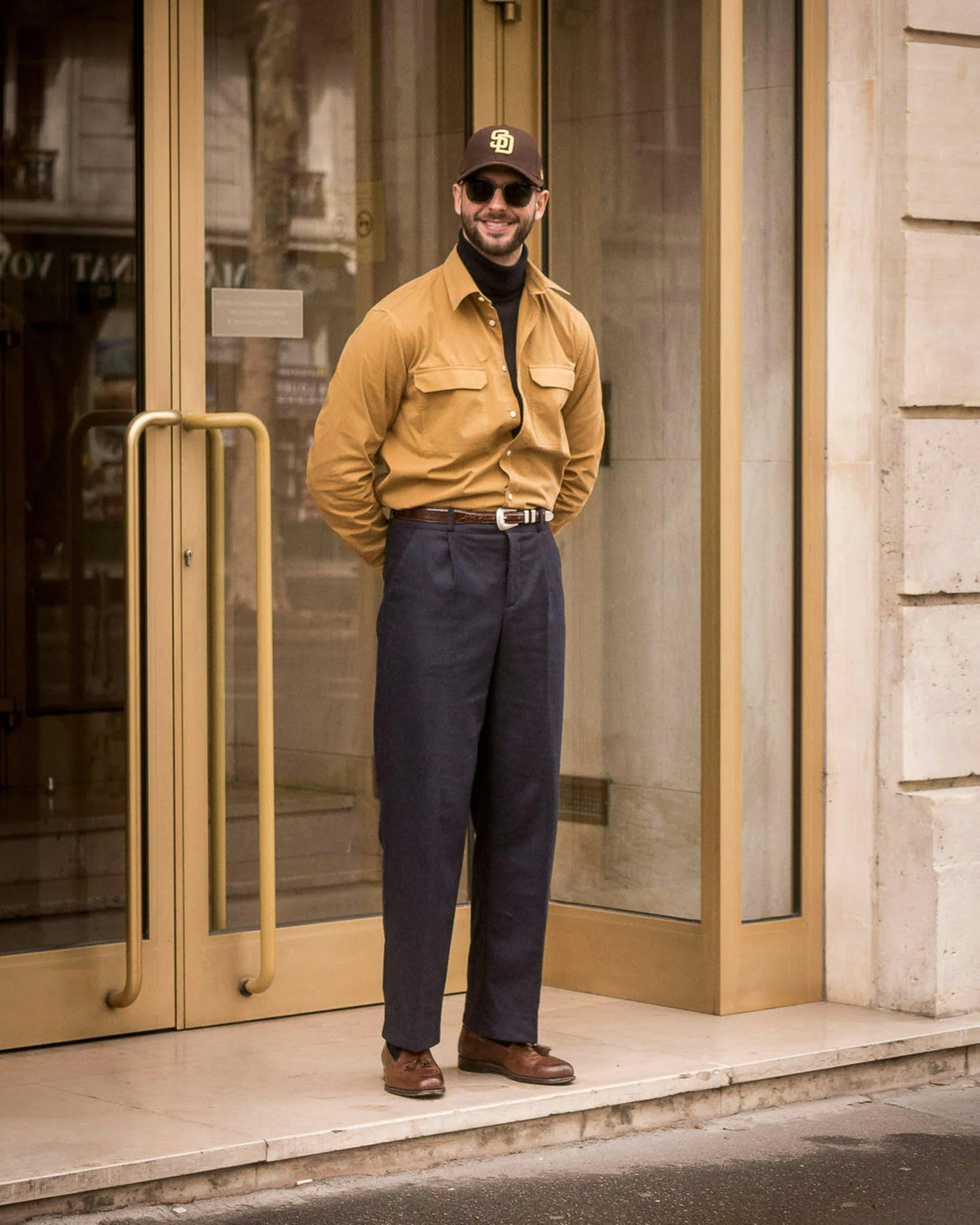 Stylish man poses outside a building
