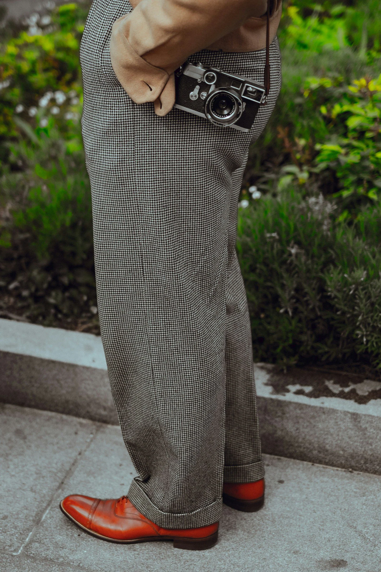 Person wearing gray dress pants with camera