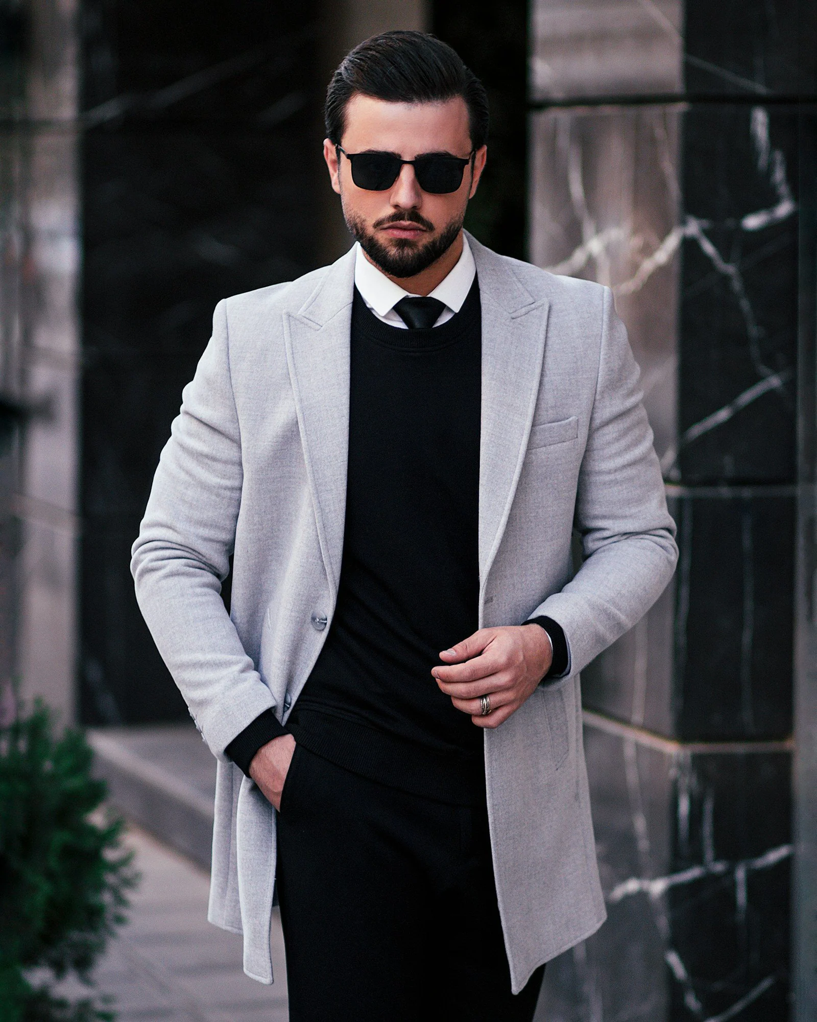 A man in a suit and tie standing on a sidewalk