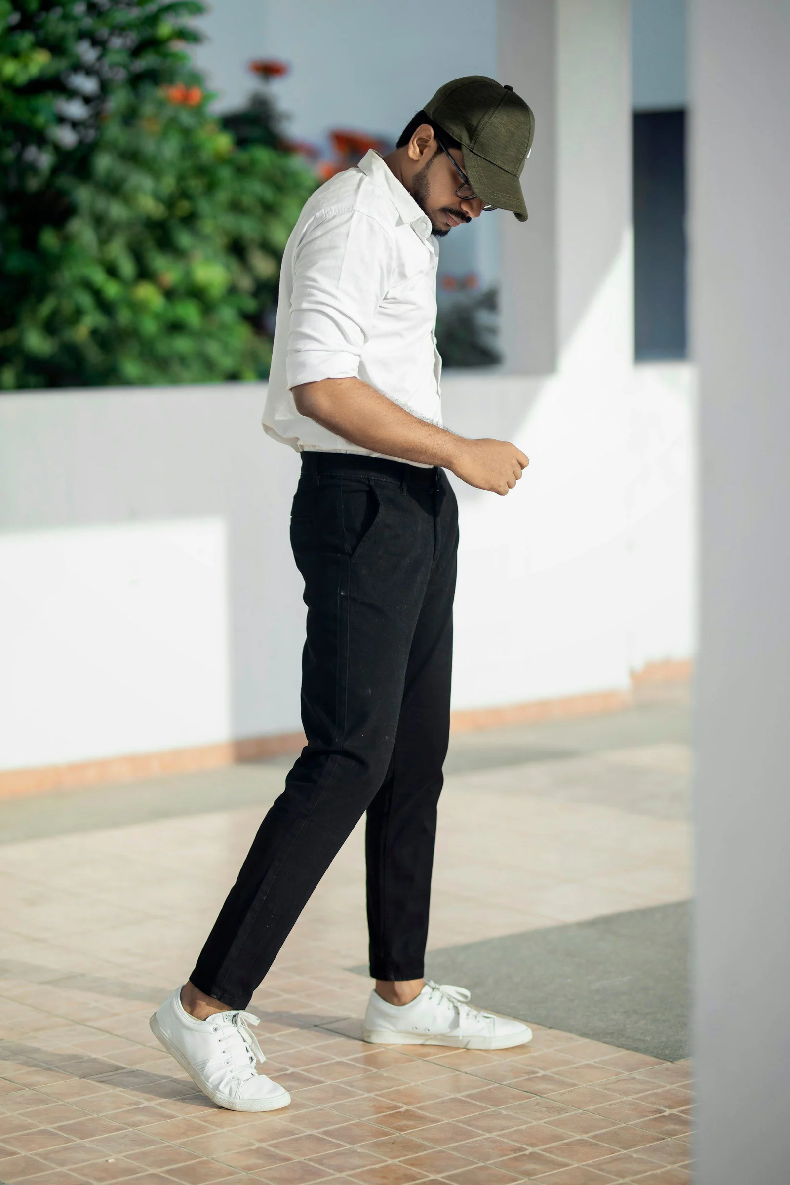 Man in white t shirt and black pants standing on white floor