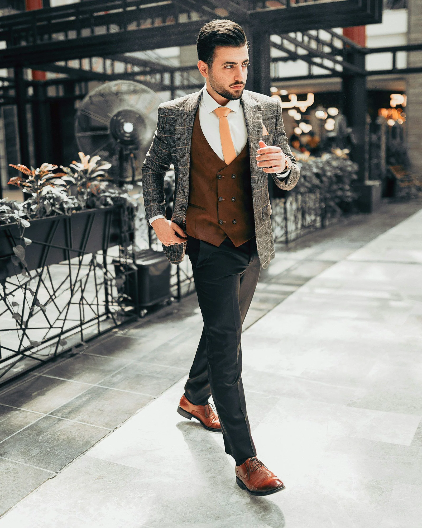 Man in black suit jacket and black pants standing on white floor