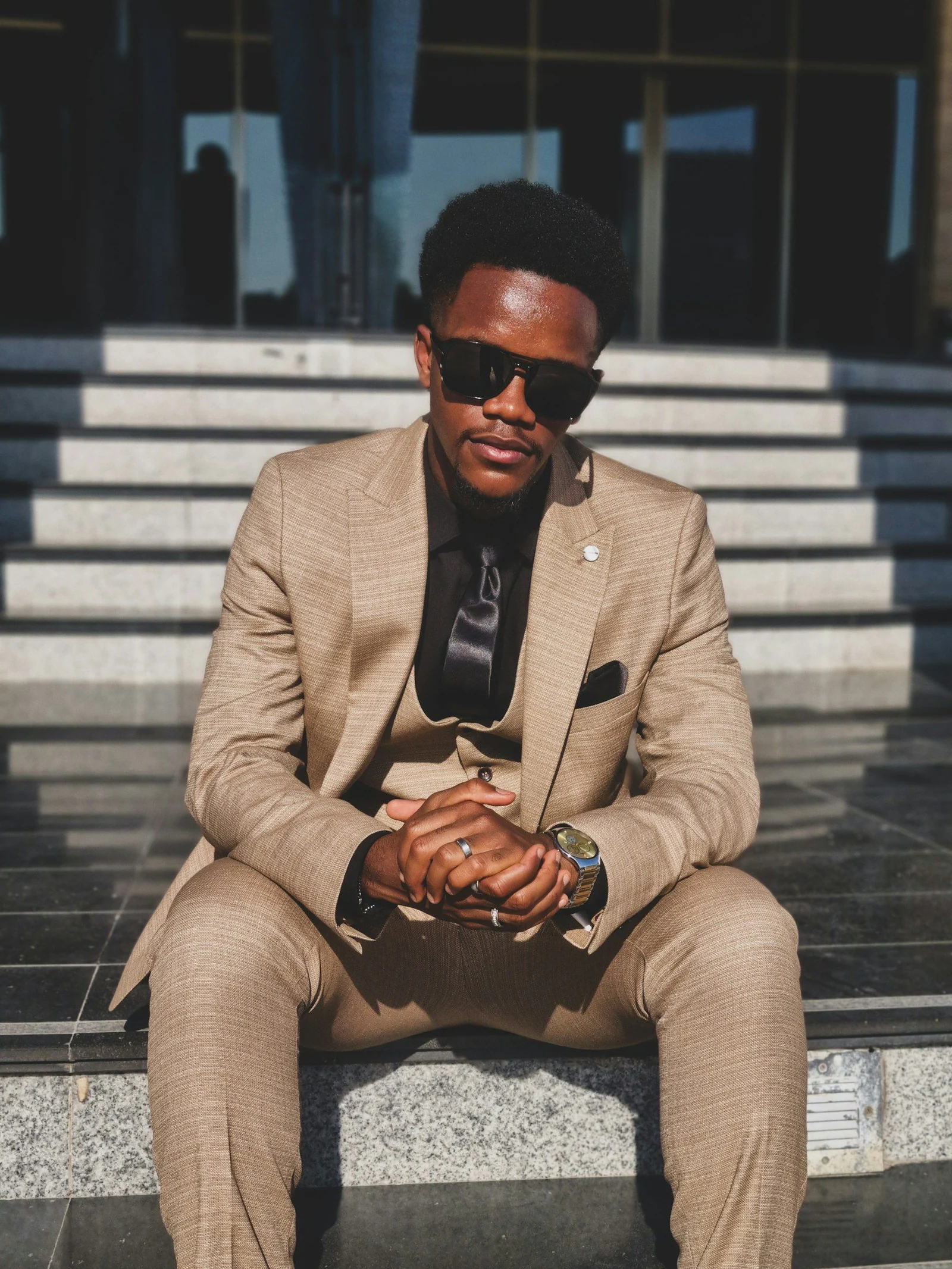 Stylish man in a suit and sunglasses poses