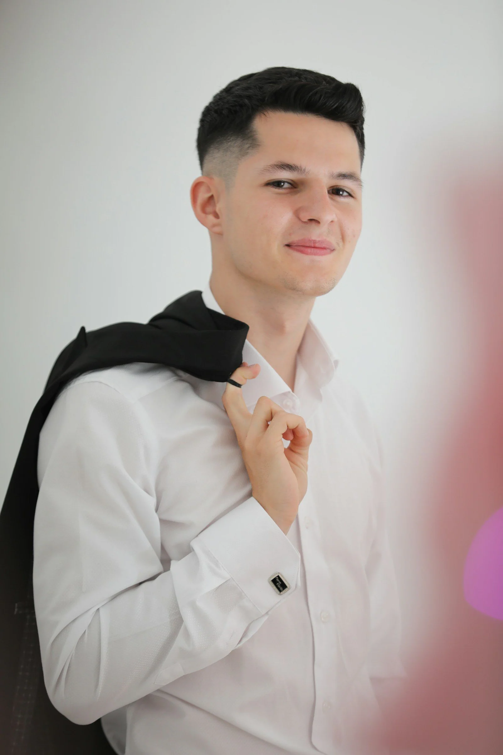 Young man in white shirt holding suit jacket