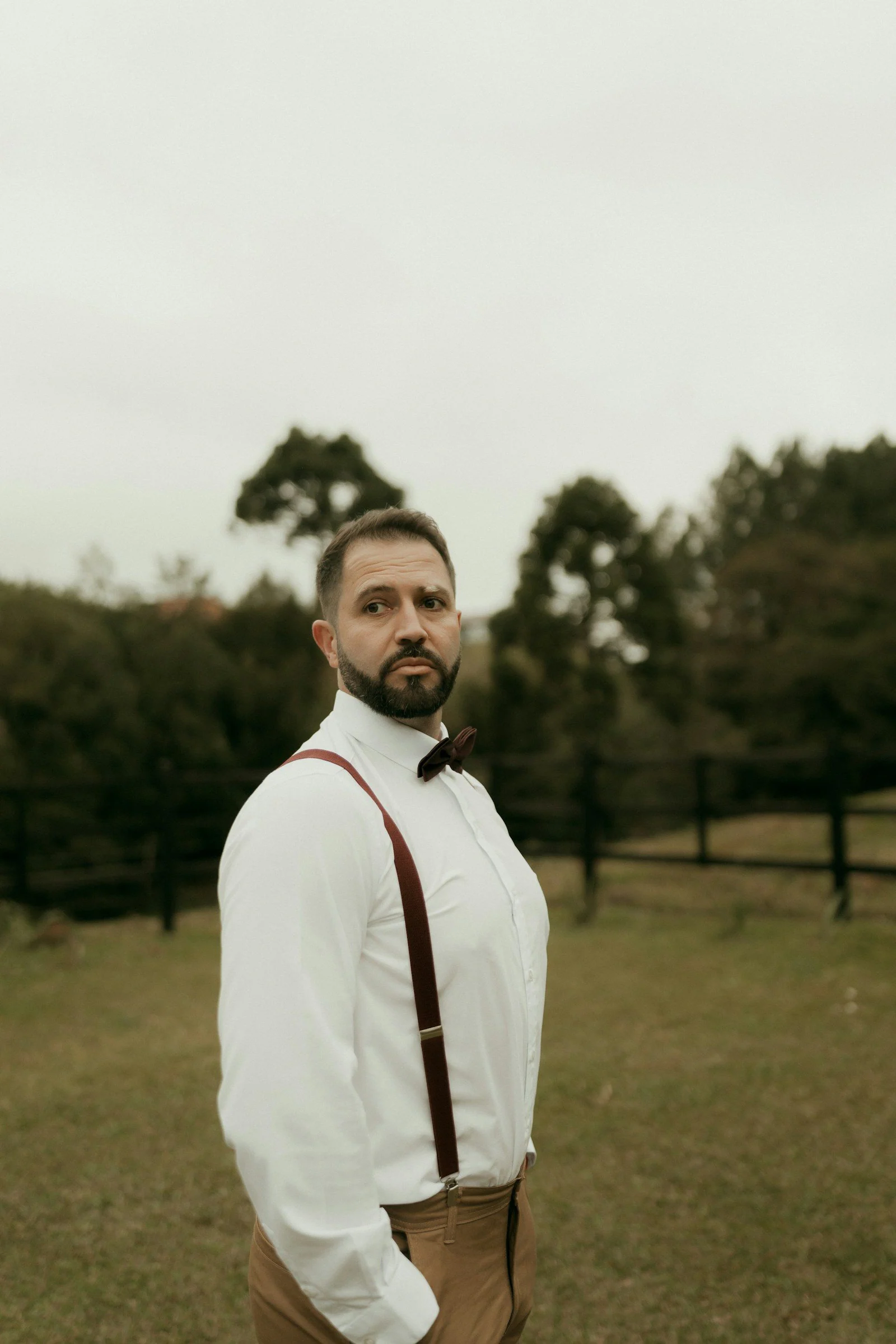 Man in white shirt bow tie and suspenders outdoors
