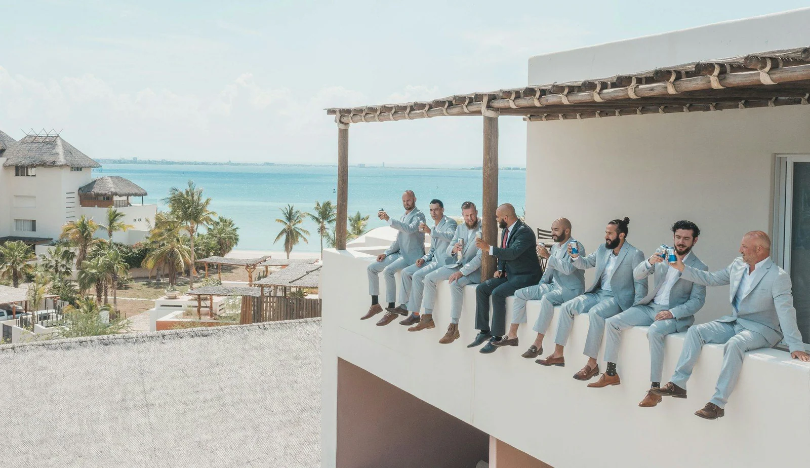 A group of men in suits sitting on a ledge