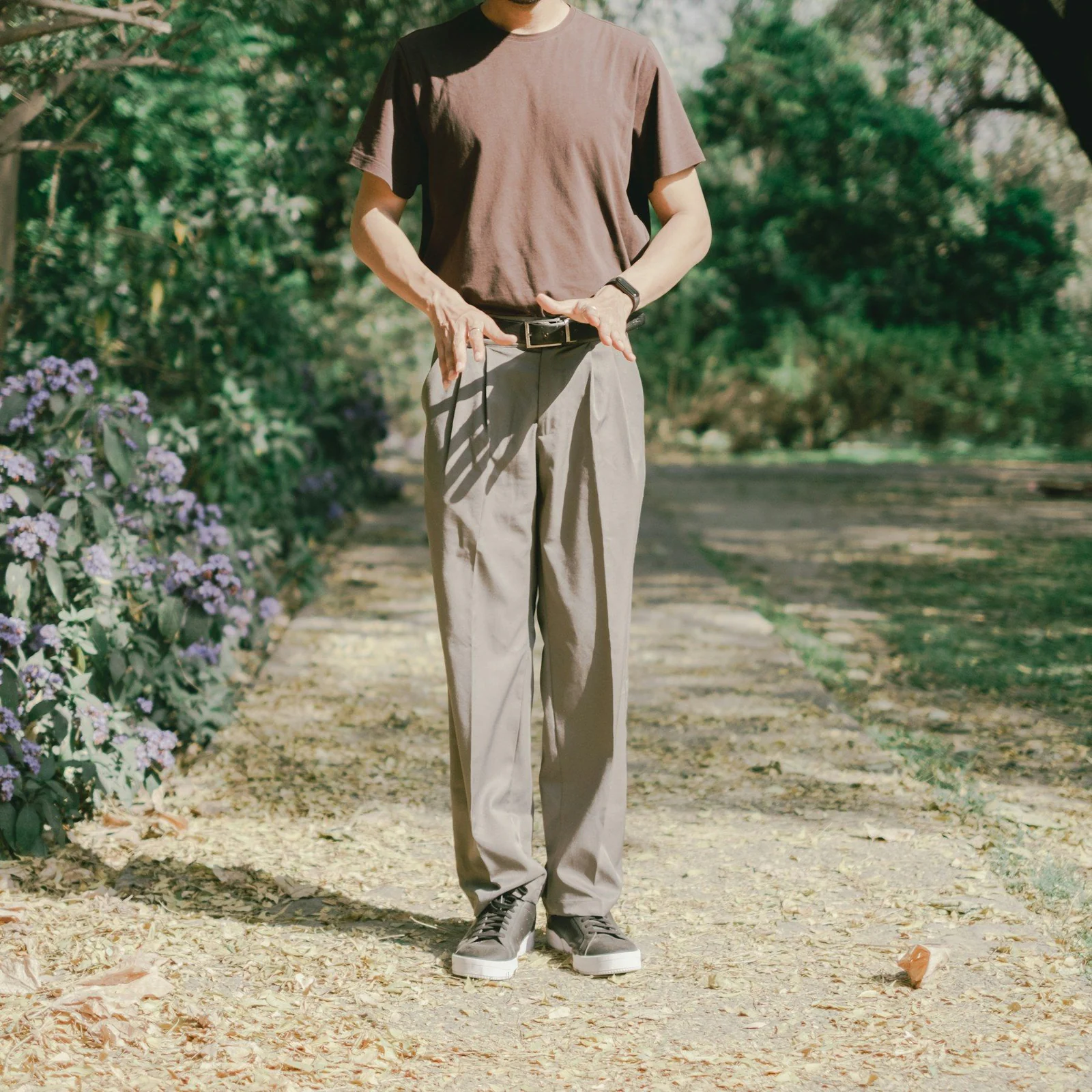 A man standing on a dirt road holding a camera