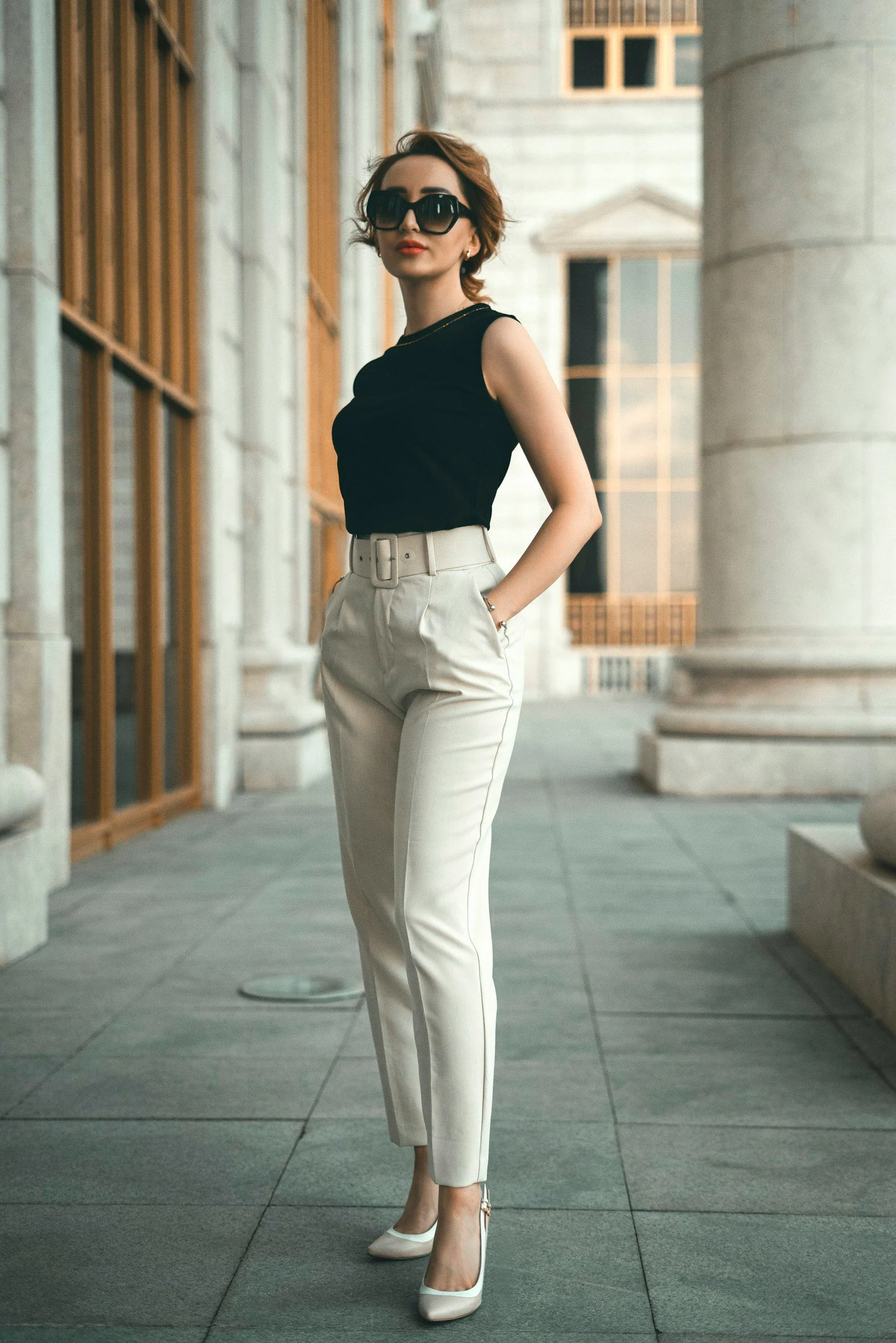 A woman in a black top and white pants