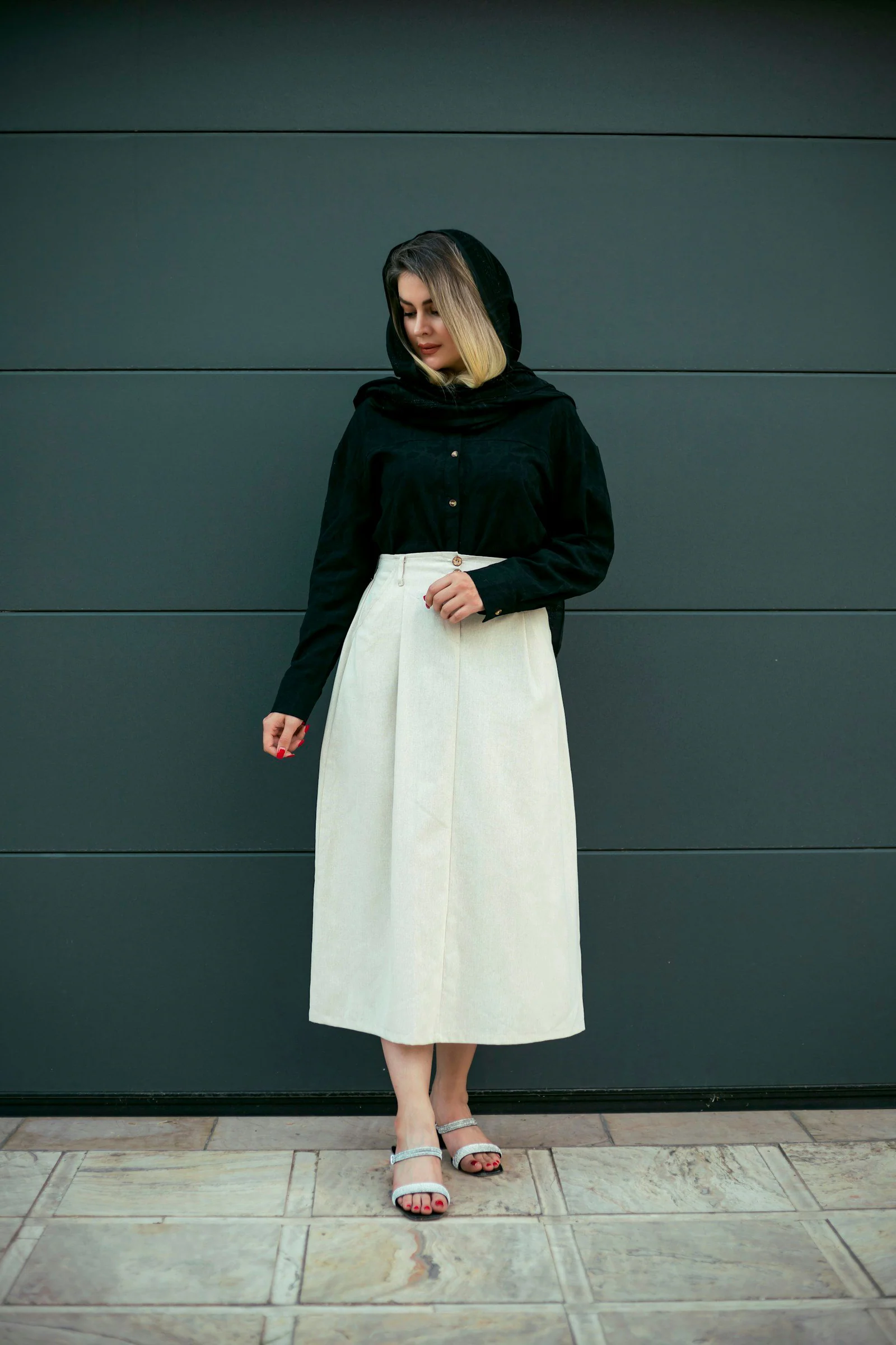 Woman in black headscarf and white skirt