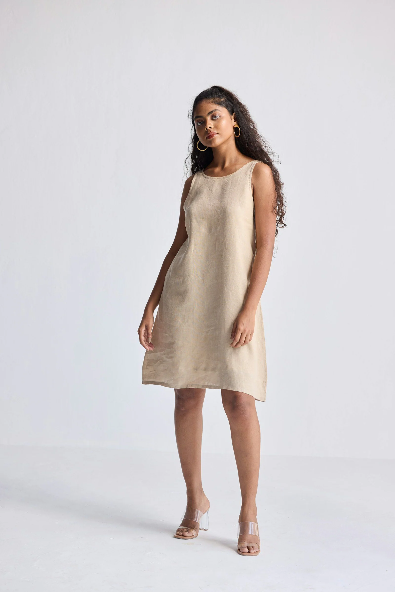 A woman poses in a simple linen dress