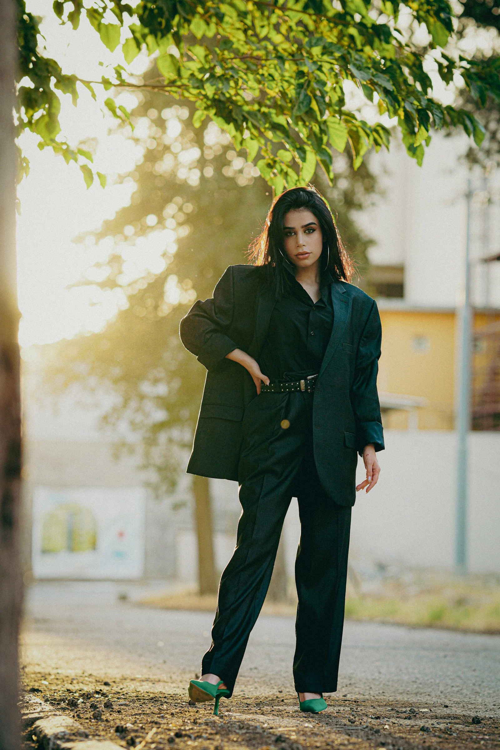 A woman in a black suit and green shoes