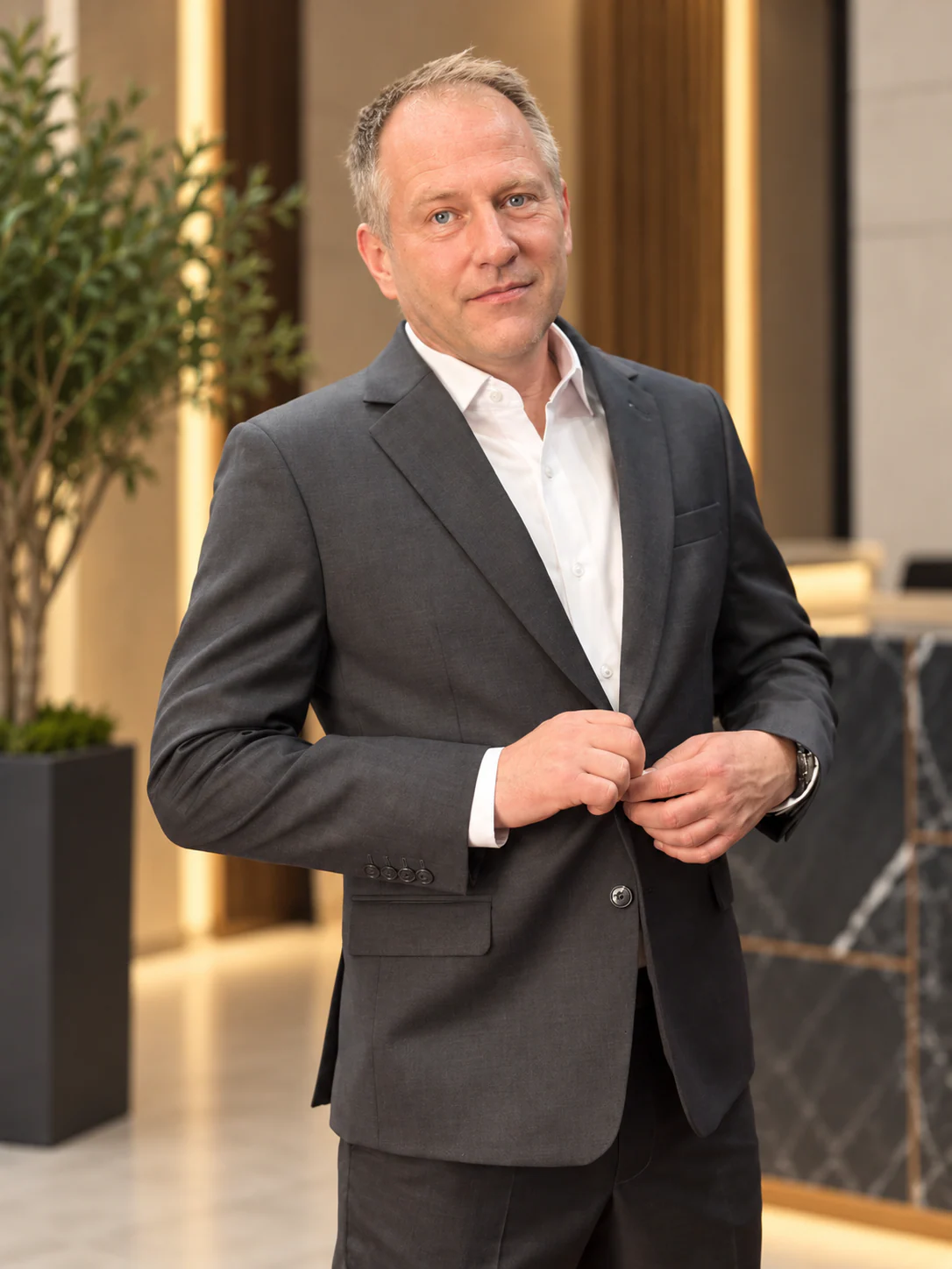 Charcoal suit, buttoning the jacket