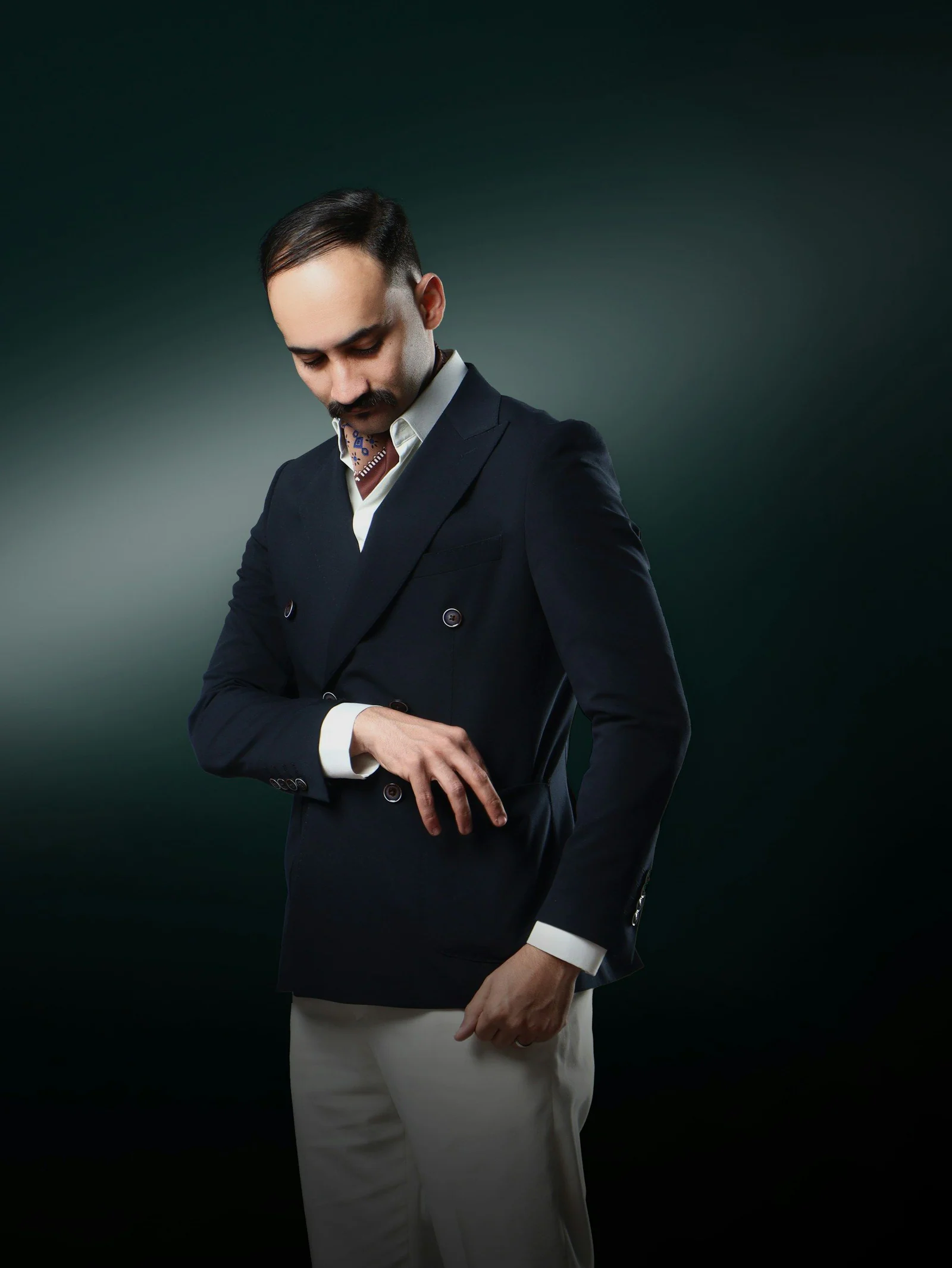 Navy double-breasted jacket, dark studio portrait