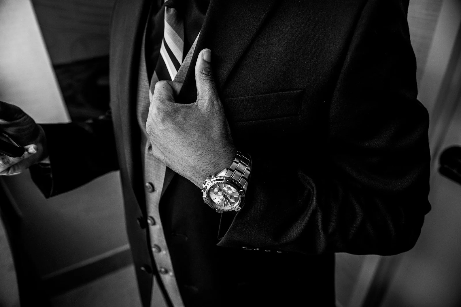 Formal suit sleeve with a steel wristwatch, black and white