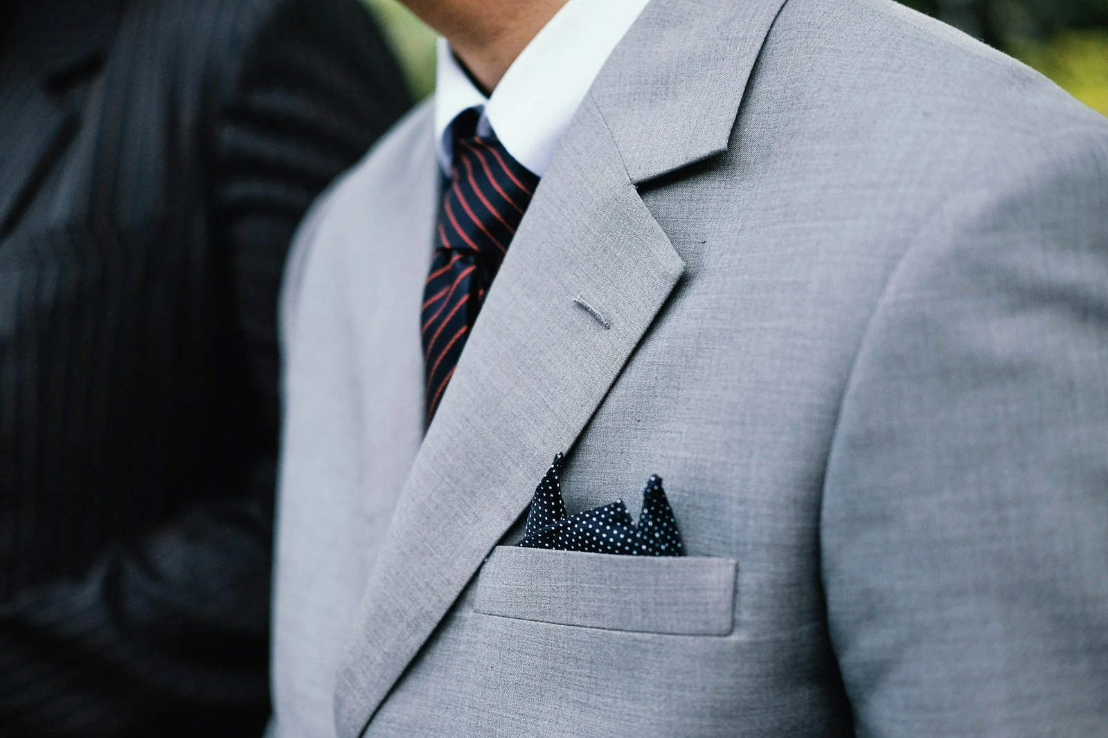 Light grey notch lapel with a patterned pocket square and striped tie