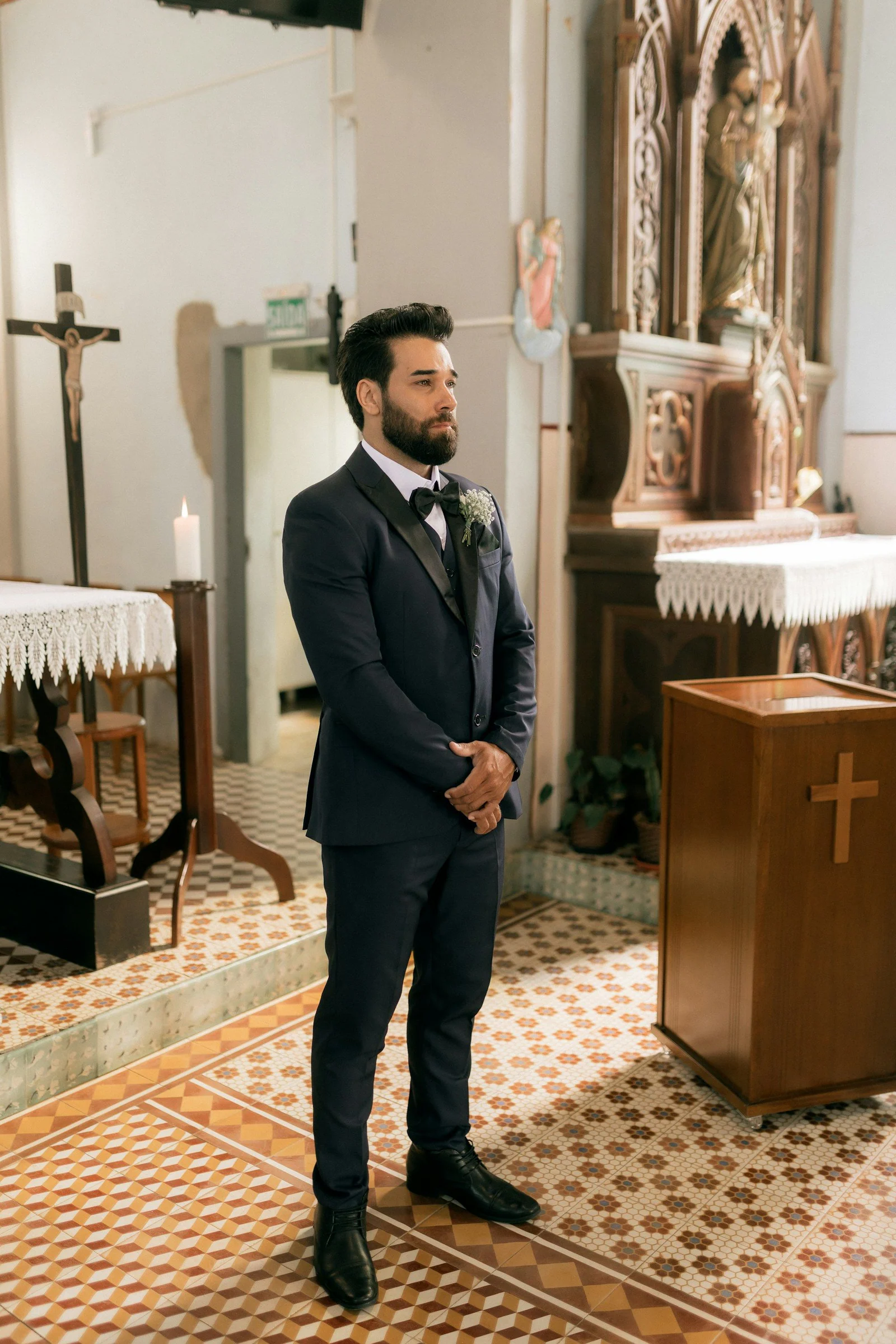 Groom in a dark suit waiting in a church